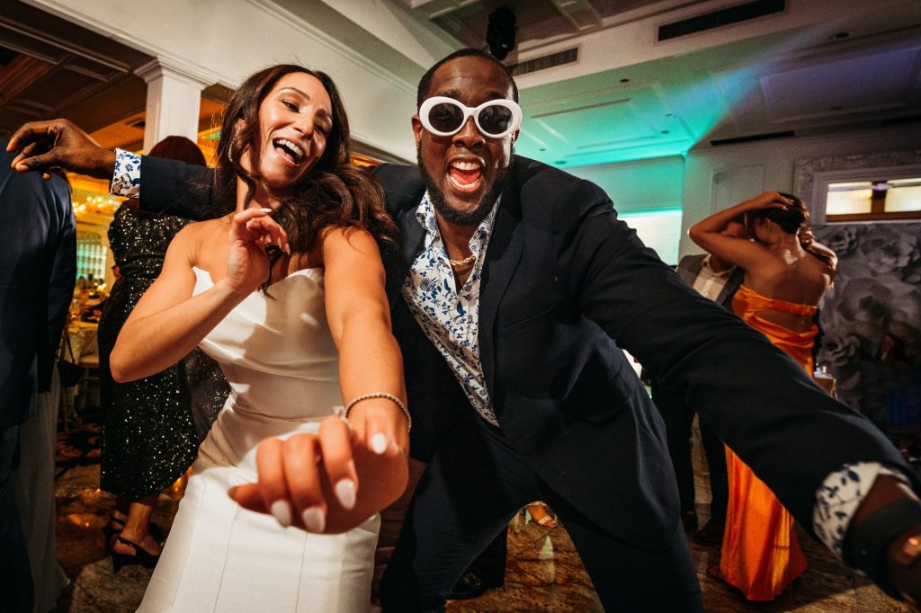 bride dancing with a guest wearing sunglasses