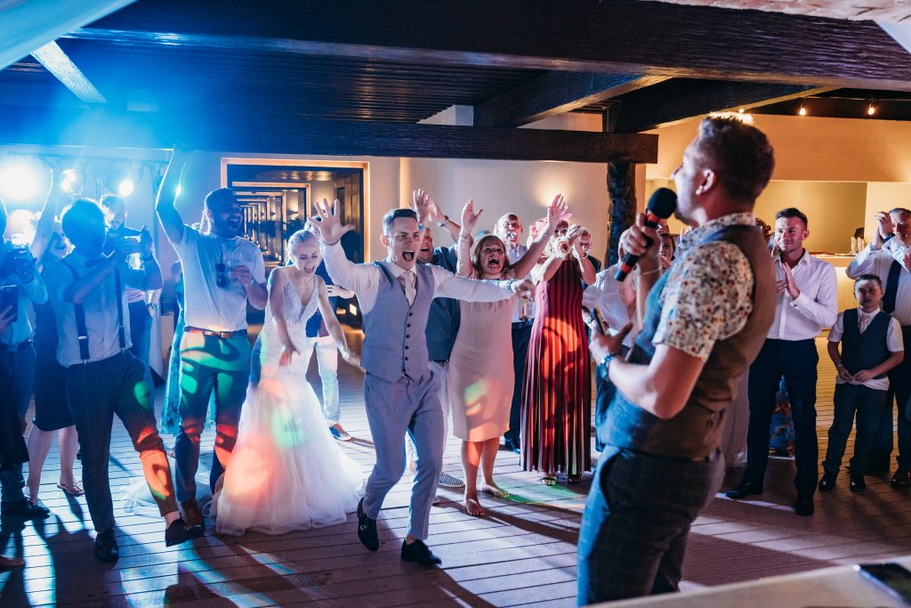 Groom running up to wedding guest who sang the final song of the night